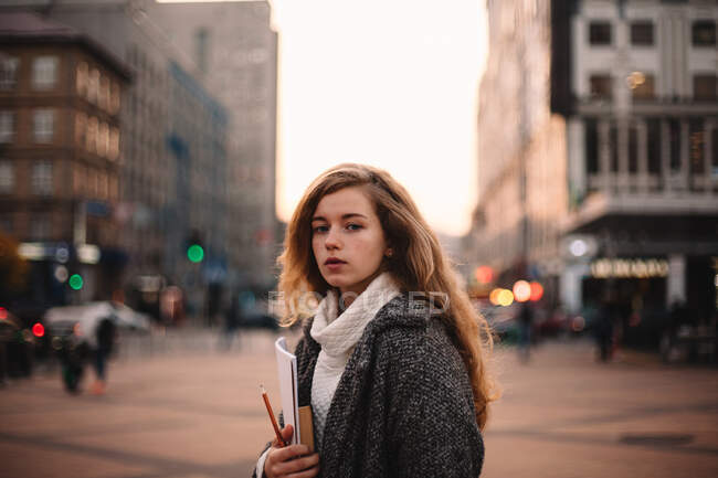 Portrait of teenage student girl standing in city during autumn — Stock Photo