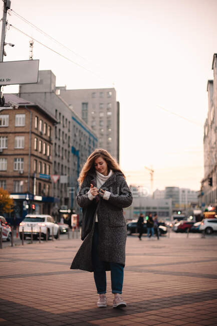 Happy teenage student girl walking in city during autumn — Stock Photo