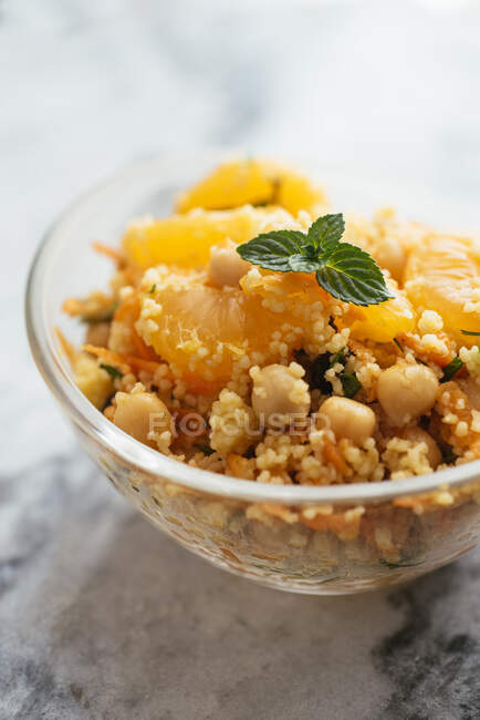 Gesunder Salat mit Couscous, Mandarinen, Orangenstücken, Kichererbsen, Petersilie und frischer Minze. — Stockfoto