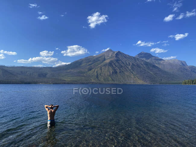 Un giovane uomo si immerge nel lago McDonald nel Glacier National Park, MT. — Foto stock