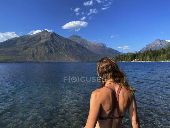 Жінка пробирається в озеро Макдональд у Глейшерському національному парку (МТ).. — стокове фото