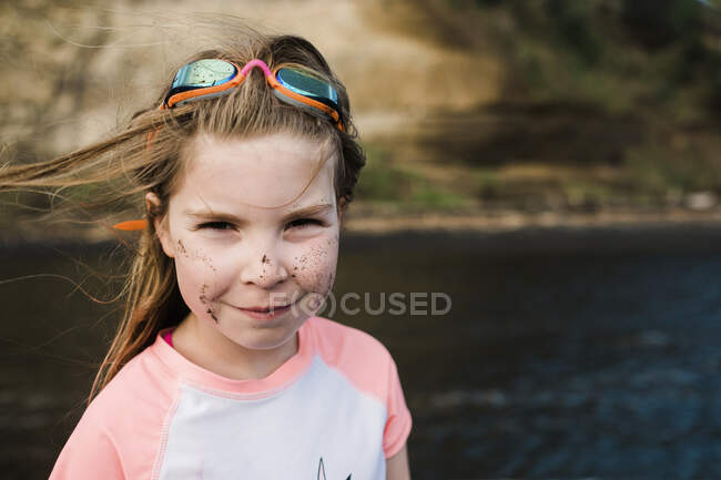 Улыбающаяся девушка на краю воды в очках — стоковое фото
