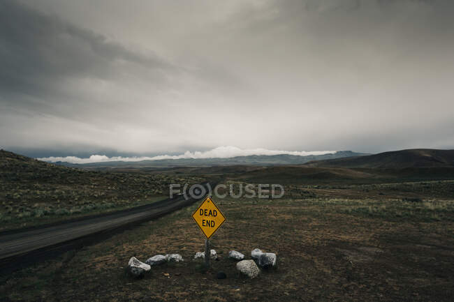 Vista de uma estrada de montanha e sinal no fundo da natureza — Fotografia de Stock