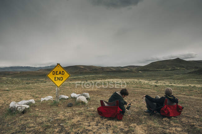 Dois homens ele em cadeiras de acampamento no meio do deserto em OU oriental. — Fotografia de Stock