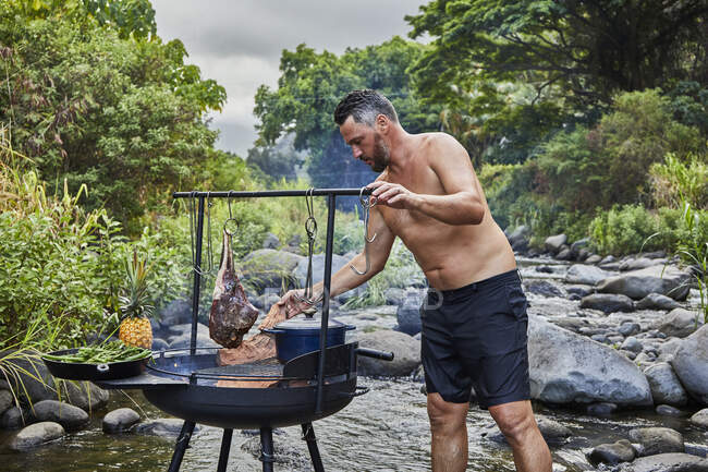 Chef Preparando Barbacoa en el Camping Cocina cerca de Stream - foto de stock