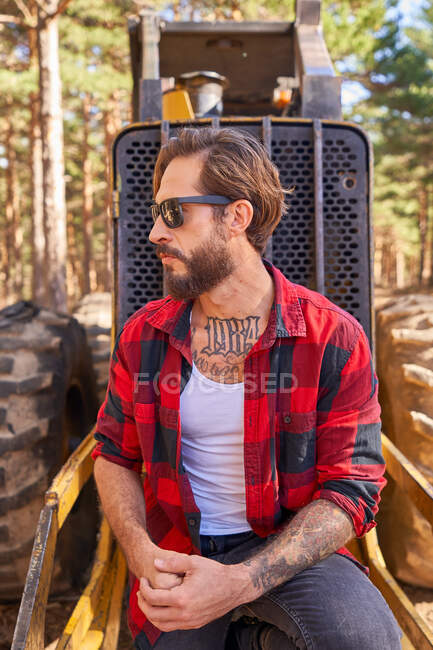 Portrait de jeune homme tatoué appuyé contre une pelle — Photo de stock