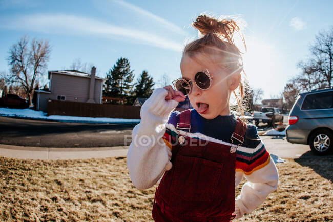 Portrait of goofy girl making silly face in front yard — Stock Photo