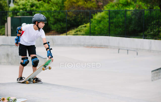 Хлопчик на скейтпарку готується спуститися вниз по бетонному каньйону — стокове фото