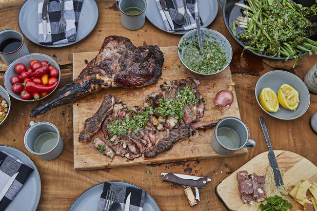 Смажений яловичий стейк з овочами та спеціями на дерев'яному столі — стокове фото