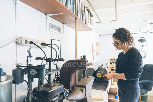 Wide shot of women working using precise tool to make a small product — Stock Photo