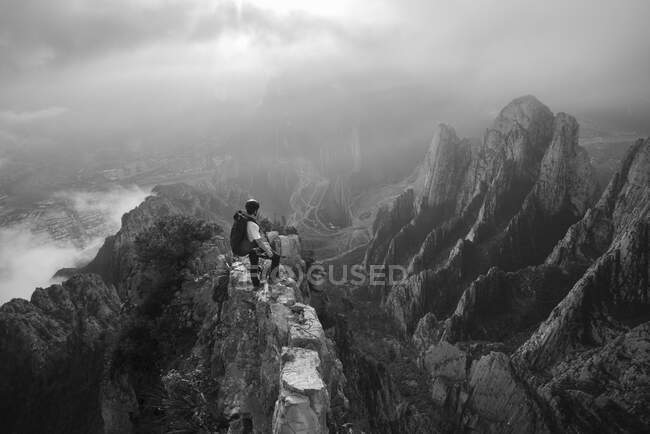 Young man climbing on rocky mountains — Stock Photo