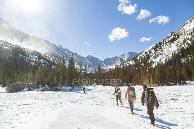 Climbers hike across frozen Mills Lake, Rocky Mountain National Park — Stock Photo