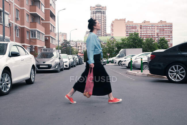 Dos mujeres jóvenes con bolsas de compras caminando por la ciudad de la mañana - foto de stock