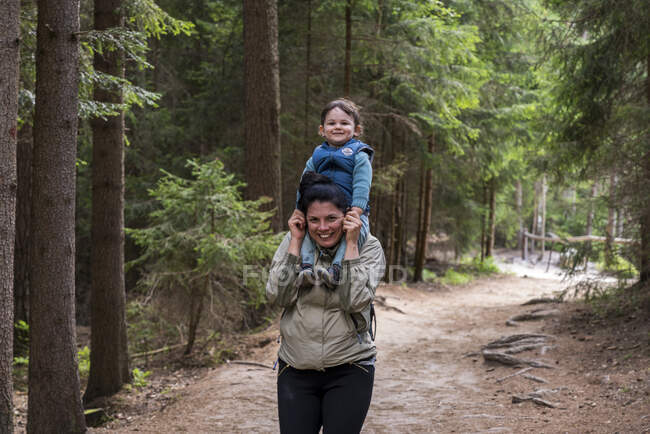 Portrait of smiling mother carrying son on shoulders while hikin — Stock Photo