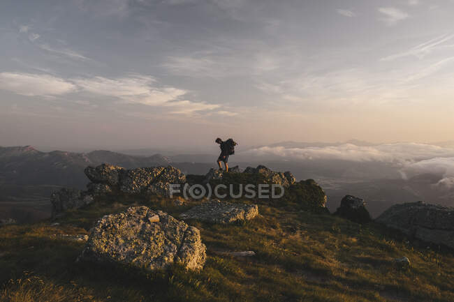 Young male with backpack hikes through some rocky terrain, Cantabria — Stock Photo
