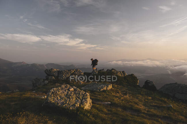 Young male with backpack hikes through some rocky terrain, Cantabria, — Stock Photo