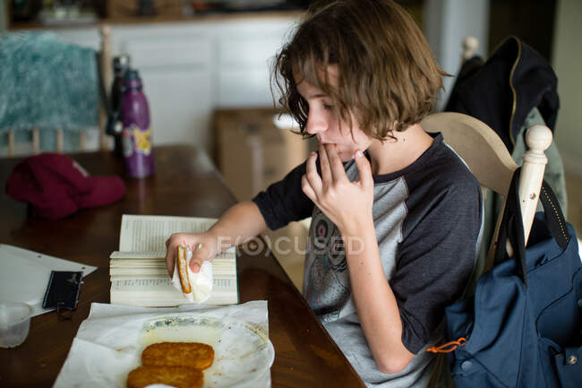 Adolescente lèche ses doigts après avoir pris une bouchée d'un hachis gras brun — Photo de stock