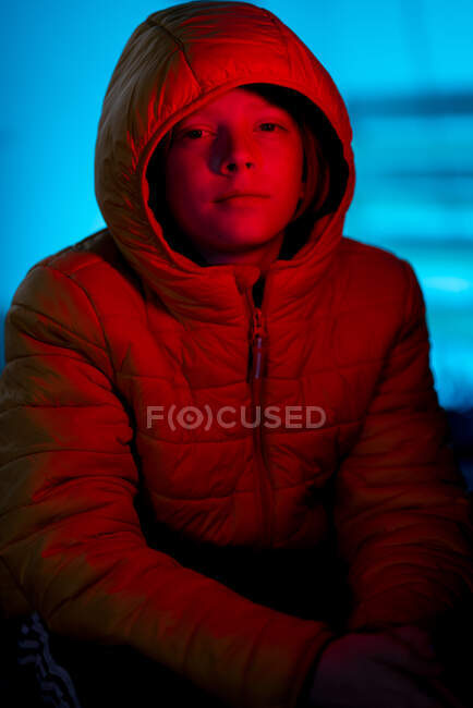 Portrait of Tween covered in red light with blue light in background — Stock Photo
