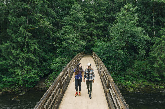 Молода пара подорожує мостом на північному заході Тихого океану.. — стокове фото