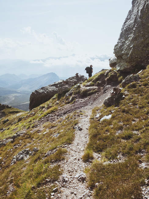 Junger Mann mit Rucksack blickt beim Klettern auf sein Ziel, den Gipfel — Stockfoto