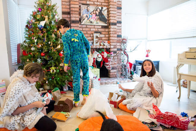Рождественское утро открытие подарков с 3 братьями и сестрами — стоковое фото