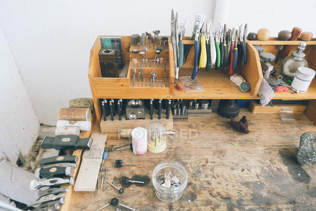 Colpo sopraelevato di banco da lavoro in legno con utensili e materiali assortiti — Foto stock