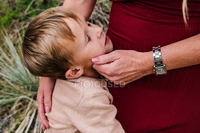 Young boy being comforted by mother outside — Stock Photo