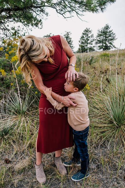 Мать утешает маленького сына в поле снаружи — стоковое фото