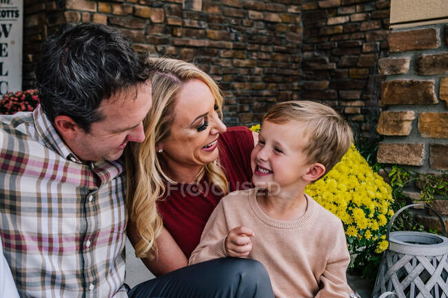 Família feliz sendo bobo na varanda da frente — Fotografia de Stock