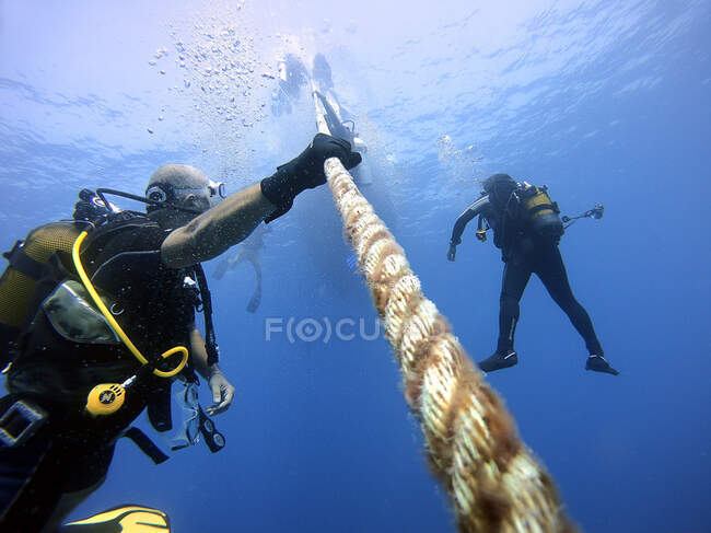 Los buzos se aferran a la cuerda del barco para esperar a la superficie. Antalya Turquía - foto de stock