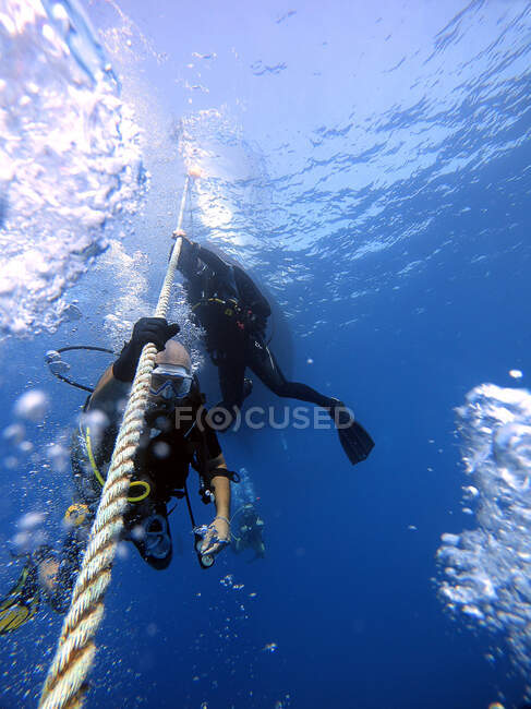 Los buzos se aferran a la cuerda del barco para esperar a la superficie. Antalya Turquía - foto de stock