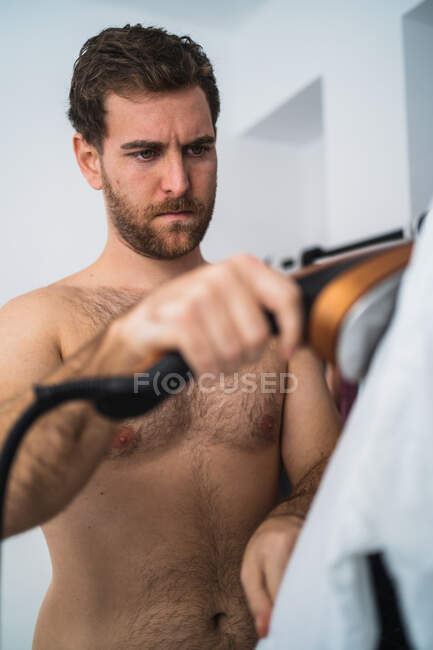 Man ironing shirt in morning — Stock Photo