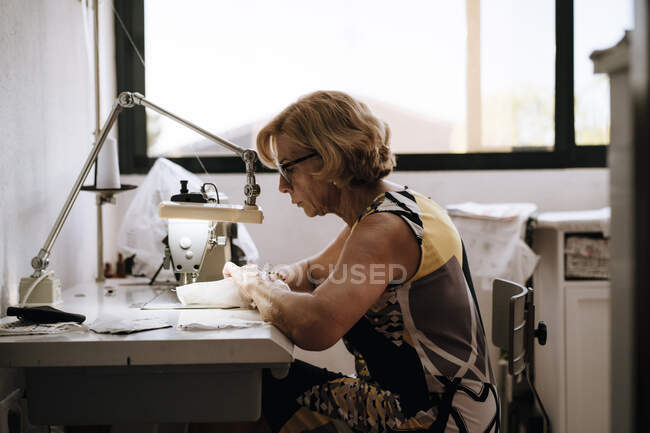 Mulher usando máquina de costura para fazer máscara médica — Fotografia de Stock
