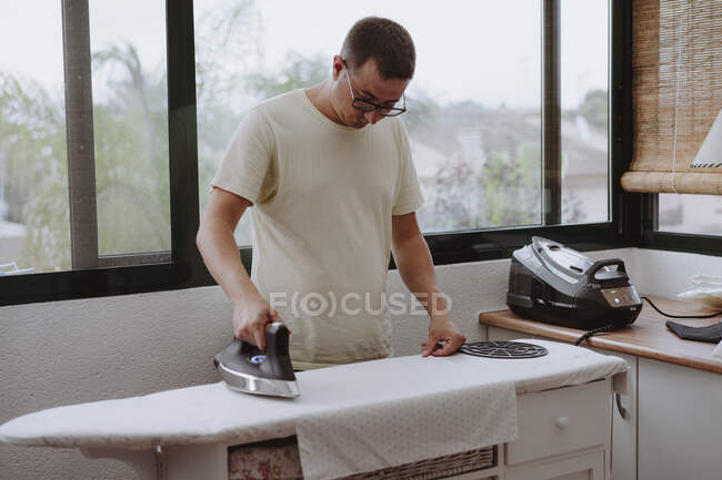 Junge Frau bügelt zu Hause, erledigt Hausarbeit — Stockfoto