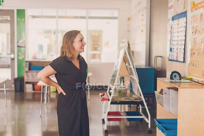 Жінка вчителька дивиться на дошку алфавіту в її класі . — стокове фото