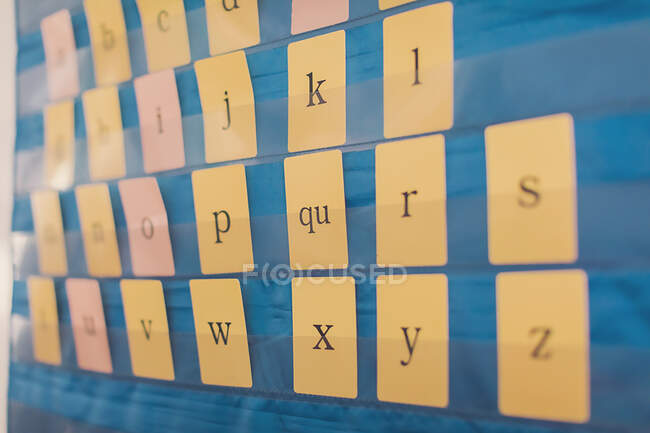 Schede alfabetiche su tabellone blu sulla parete della Scuola Elementare. — Foto stock