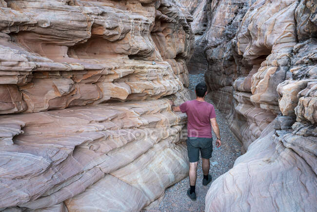 Junger Mann läuft durch den White Domes Slot Canyon (MR), Valley of Fire State Park, Nevada, USA — Stockfoto