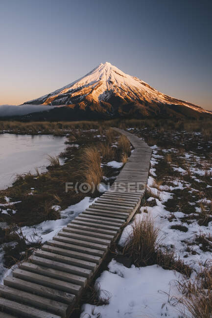 Sentiero in legno verso il Monte Taranaki nell'isola nord della Nuova Zelanda al tramonto — Foto stock