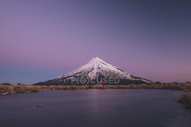 Young woman on a Yoga pose at the foot fo Mt Taranaki during early blue hour, New Zealand — Stock Photo
