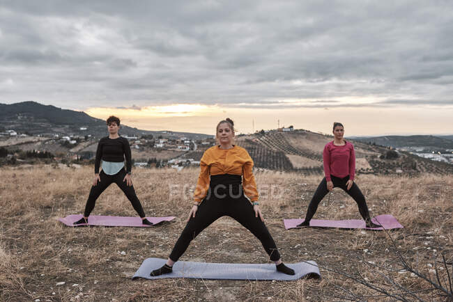 Groupe de femmes pratiquant le Pilates à la campagne — Photo de stock