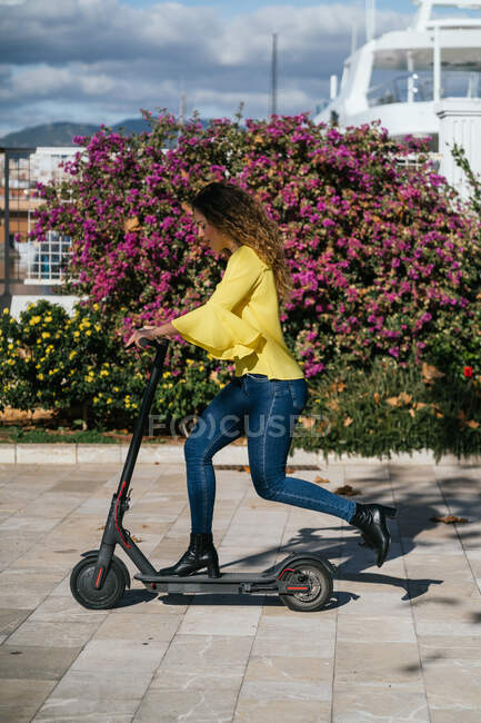 Giovane donna a cavallo scooter il giorno d'estate — Foto stock