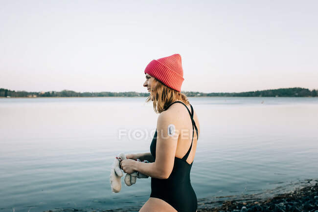 Donna che entra nell'acqua calma pronta per il nuoto in acqua fredda in Svezia — Foto stock