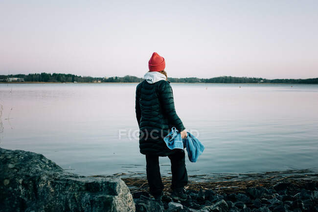 Femme regardant vers la mer nordique prêt à aller nager en eau froide — Photo de stock