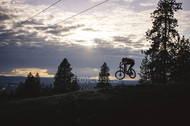 Горный байкер прыгает на закате в Спокане, штат Вашингтон — стоковое фото