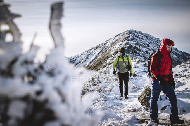 Due escursionisti invernali sul sentiero ghiacciato innevato nelle montagne del New Hampshire — Foto stock