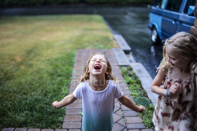 Little girl screaming in the rain in spring — Stock Photo