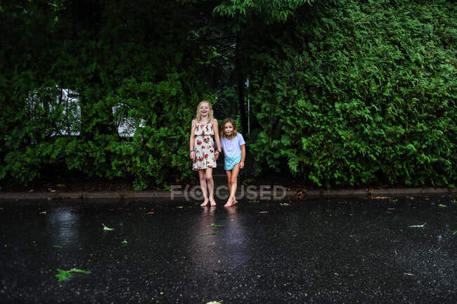 Portrait of two girls standing in the rain — Stock Photo