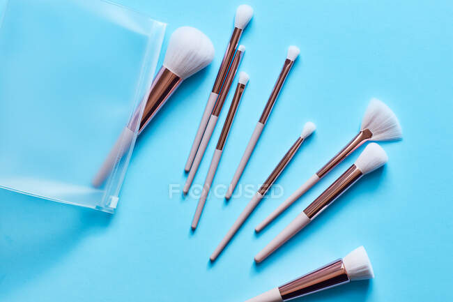 Assortment of Makeup brushes on turquoise surface — Stock Photo