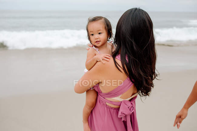 Jovem asiático com bebê menina na praia — Fotografia de Stock