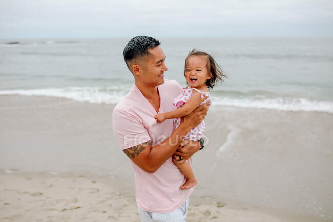 Молодий азіатський жир з дитиною розважається на пляжі — стокове фото